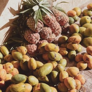 Organic mangoes and pineapples at a sunlit market in Zanzibar.