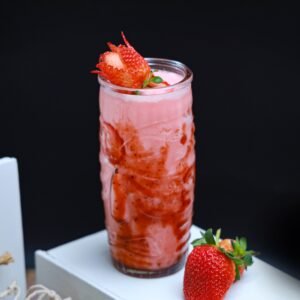 A vibrant strawberry smoothie topped with fresh fruit, perfect for a healthy lifestyle.