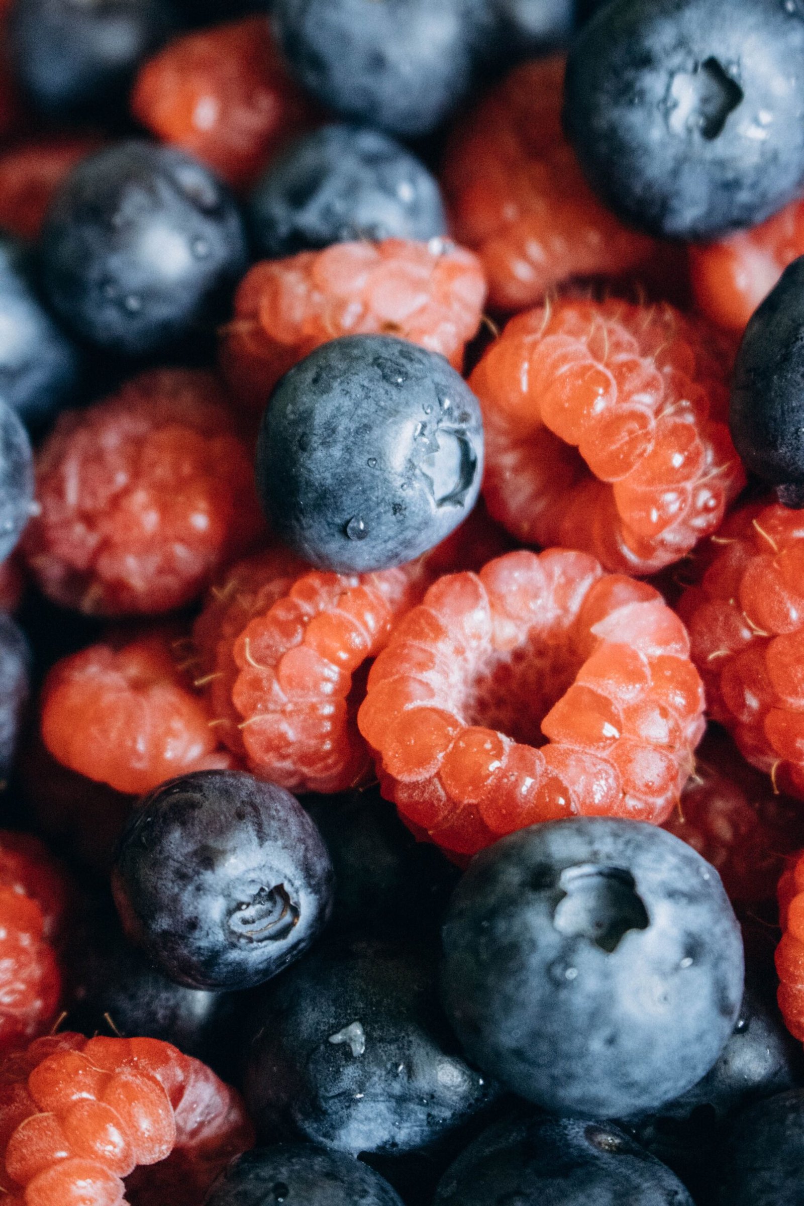 About Close-up view of fresh blueberries and raspberries, highlighting their vibrant colors and textures.